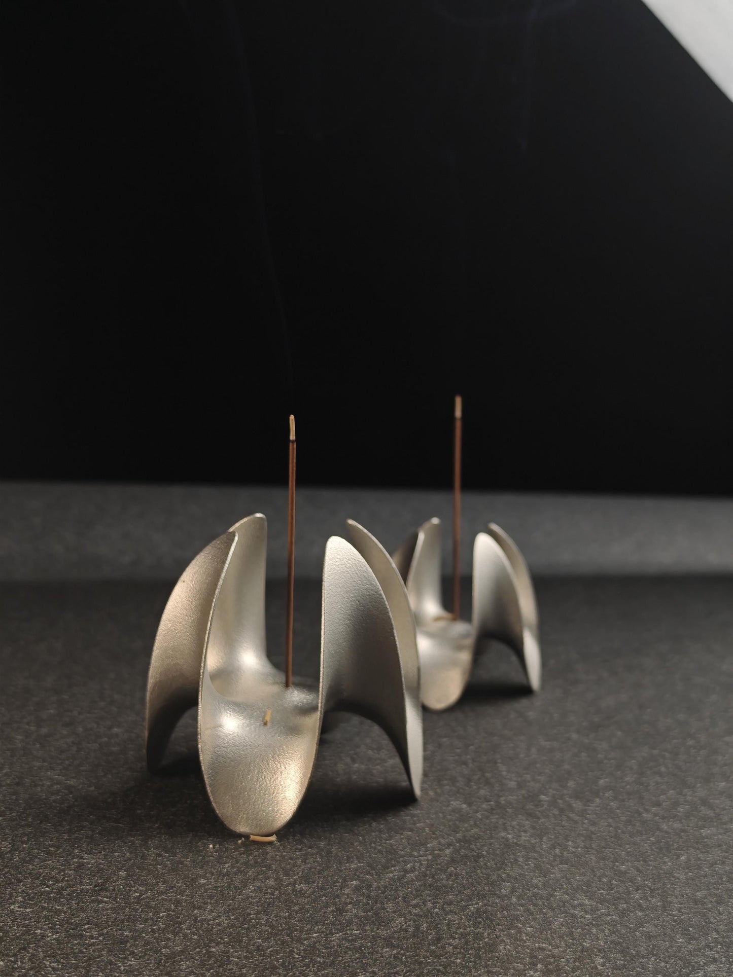 A sculptural incense holder crafted from aerospace-grade aluminum alloy, featuring a flowing cyberpunk-inspired form and a matte silver finish. Designed for modern interiors, meditation spaces, or futuristic decor setups.