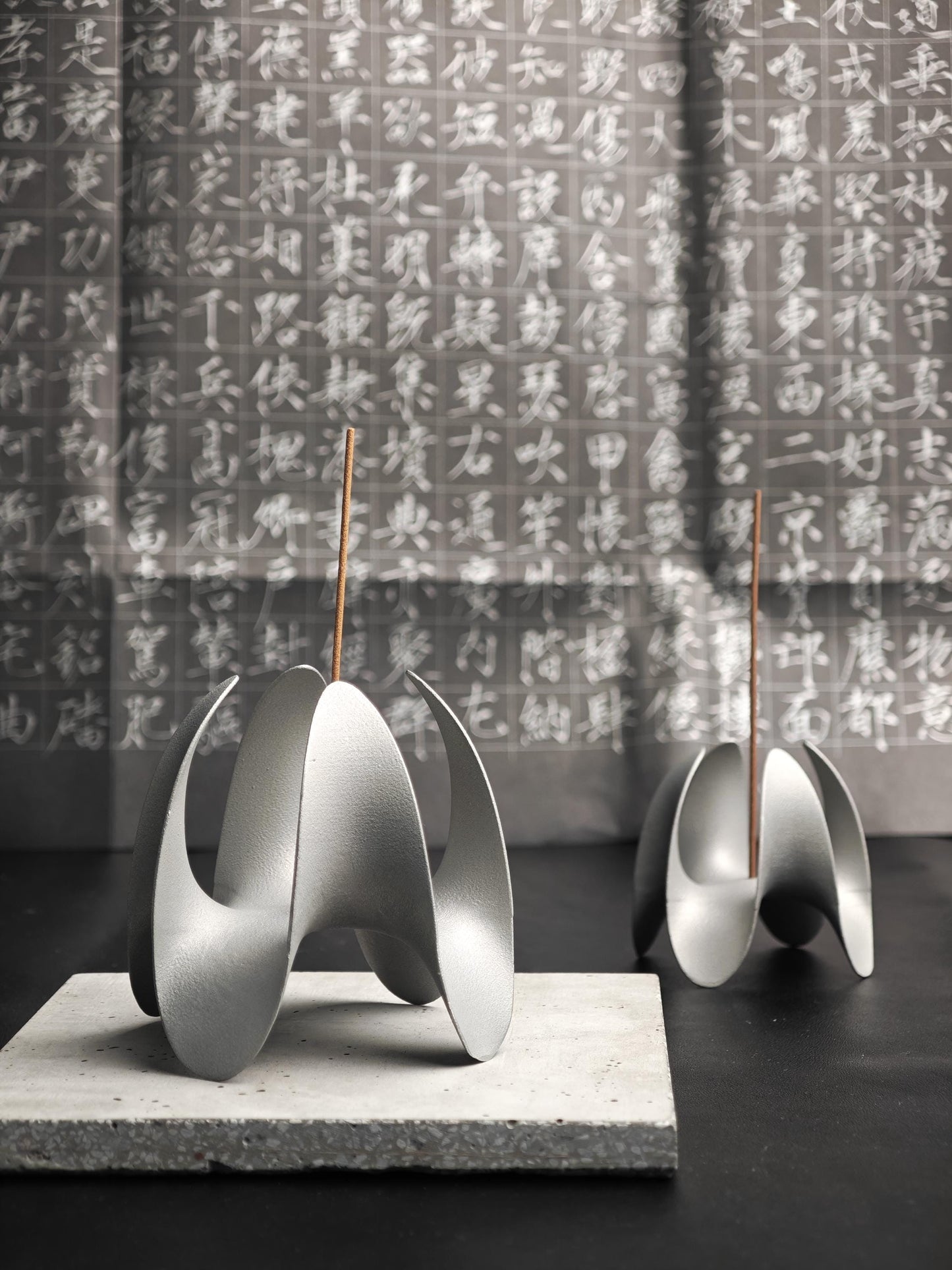 A sculptural incense holder crafted from aerospace-grade aluminum alloy, featuring a flowing cyberpunk-inspired form and a matte silver finish. Designed for modern interiors, meditation spaces, or futuristic decor setups.