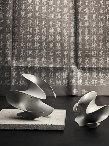 A sculptural incense holder crafted from aerospace-grade aluminum alloy, featuring a flowing cyberpunk-inspired form and a matte silver finish. Designed for modern interiors, meditation spaces, or futuristic decor setups.