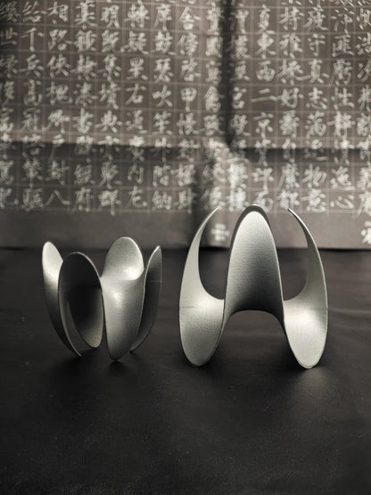 A sculptural incense holder crafted from aerospace-grade aluminum alloy, featuring a flowing cyberpunk-inspired form and a matte silver finish. Designed for modern interiors, meditation spaces, or futuristic decor setups.